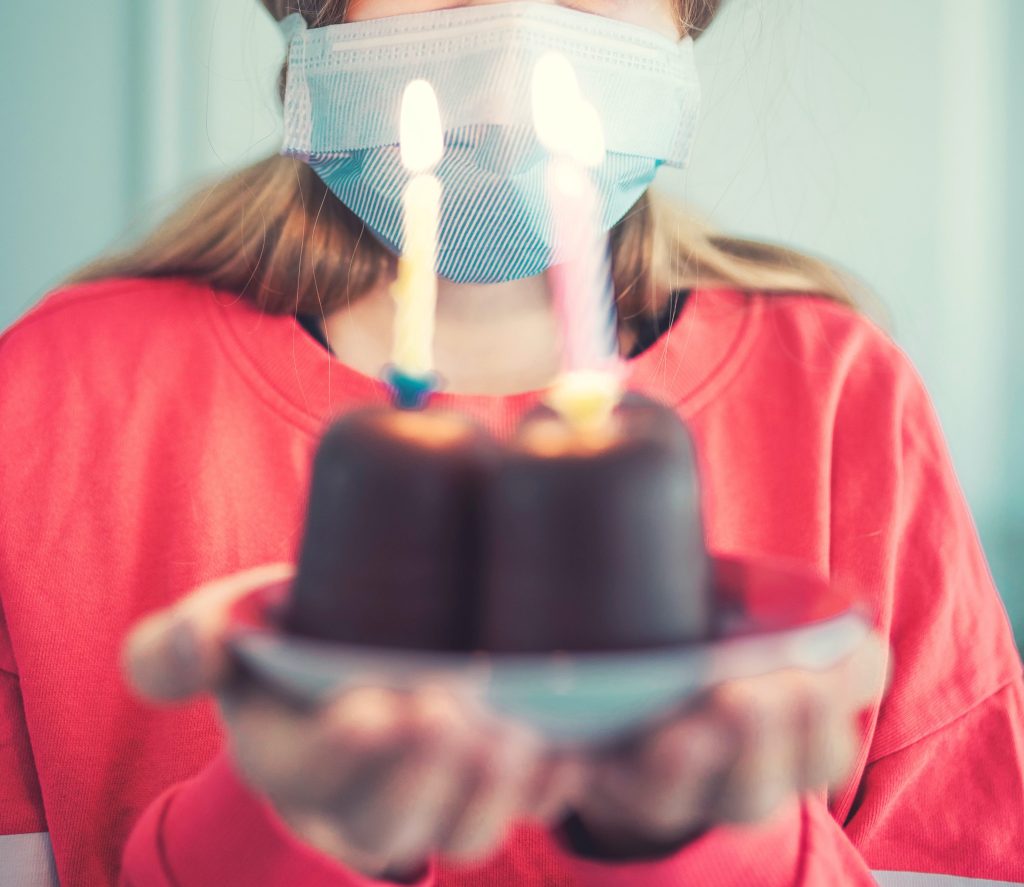 Lockdown birthday - girl in a mask with cake